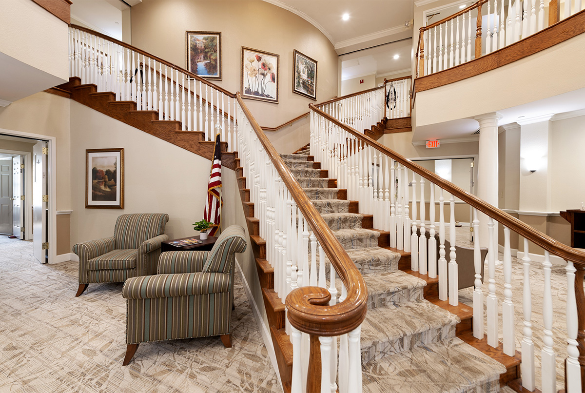 Interior staircase with seating area and artwork.
