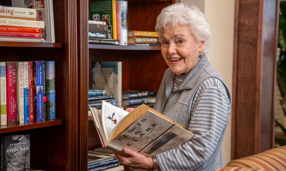 Senior woman enjoying a book in the library.