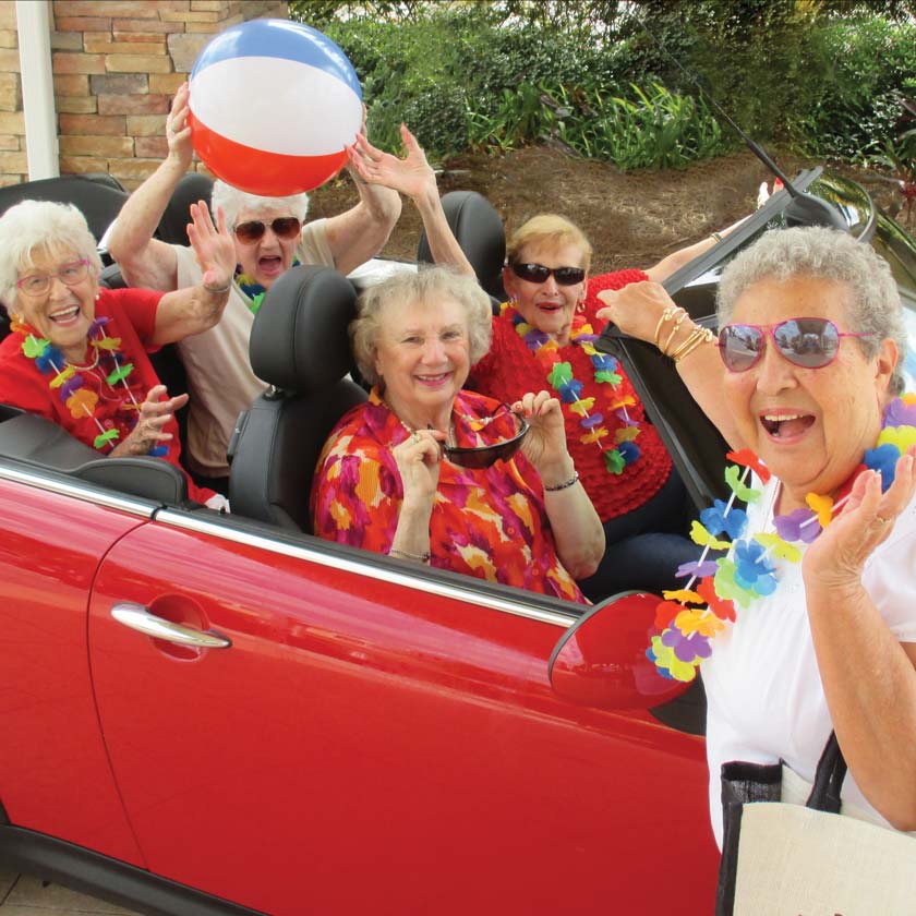 Seniors enjoying a beach ball in a car