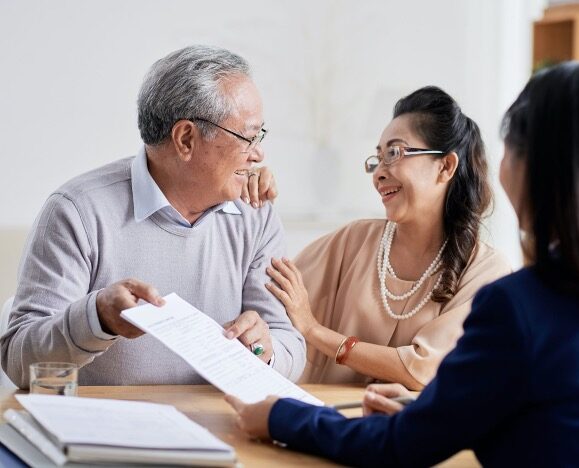 Two residents interacting with a staff member at a table.