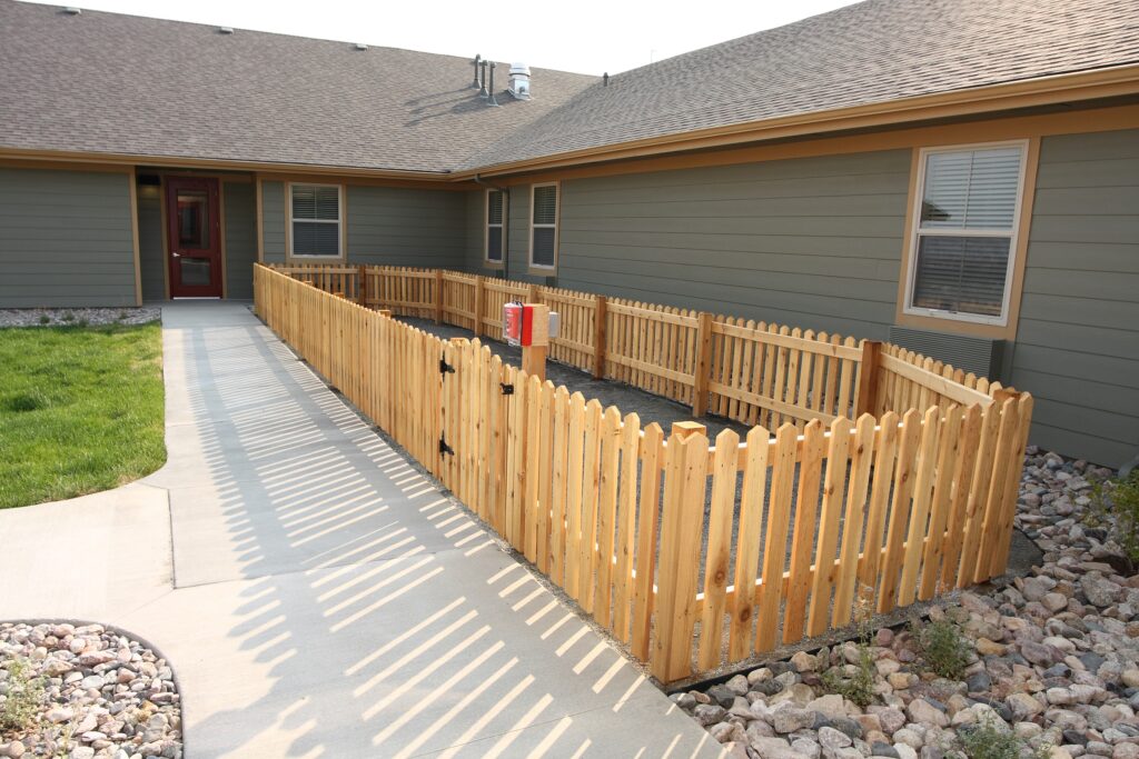 Outdoor fenced area with a path and grass.