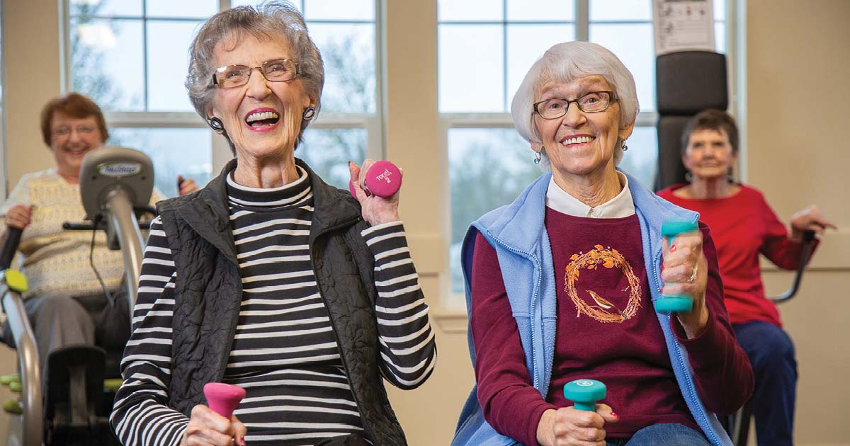 Seniors participating in a fitness class with hand weights