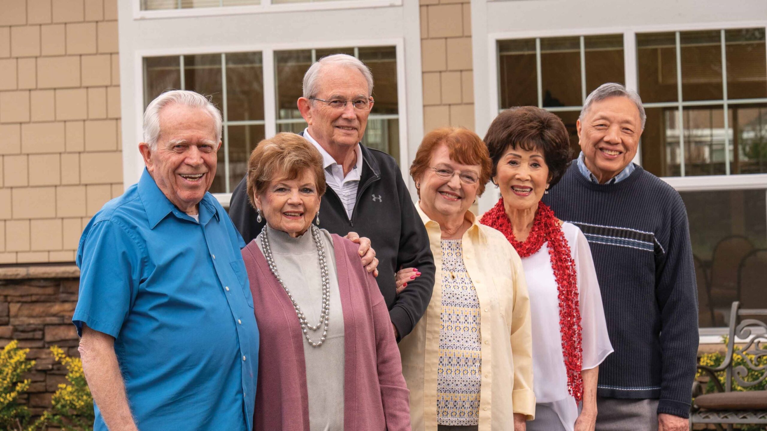 Group of residents smiling outside in a garden