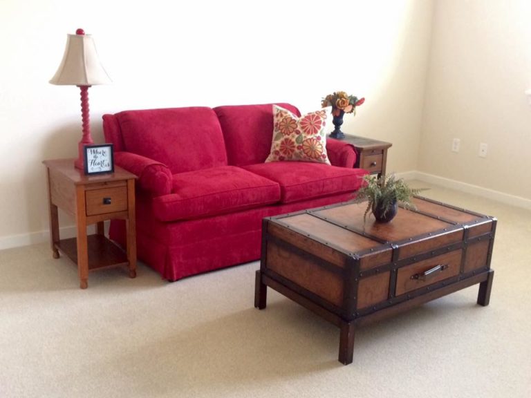 Cozy living room area with red couch and decorative table