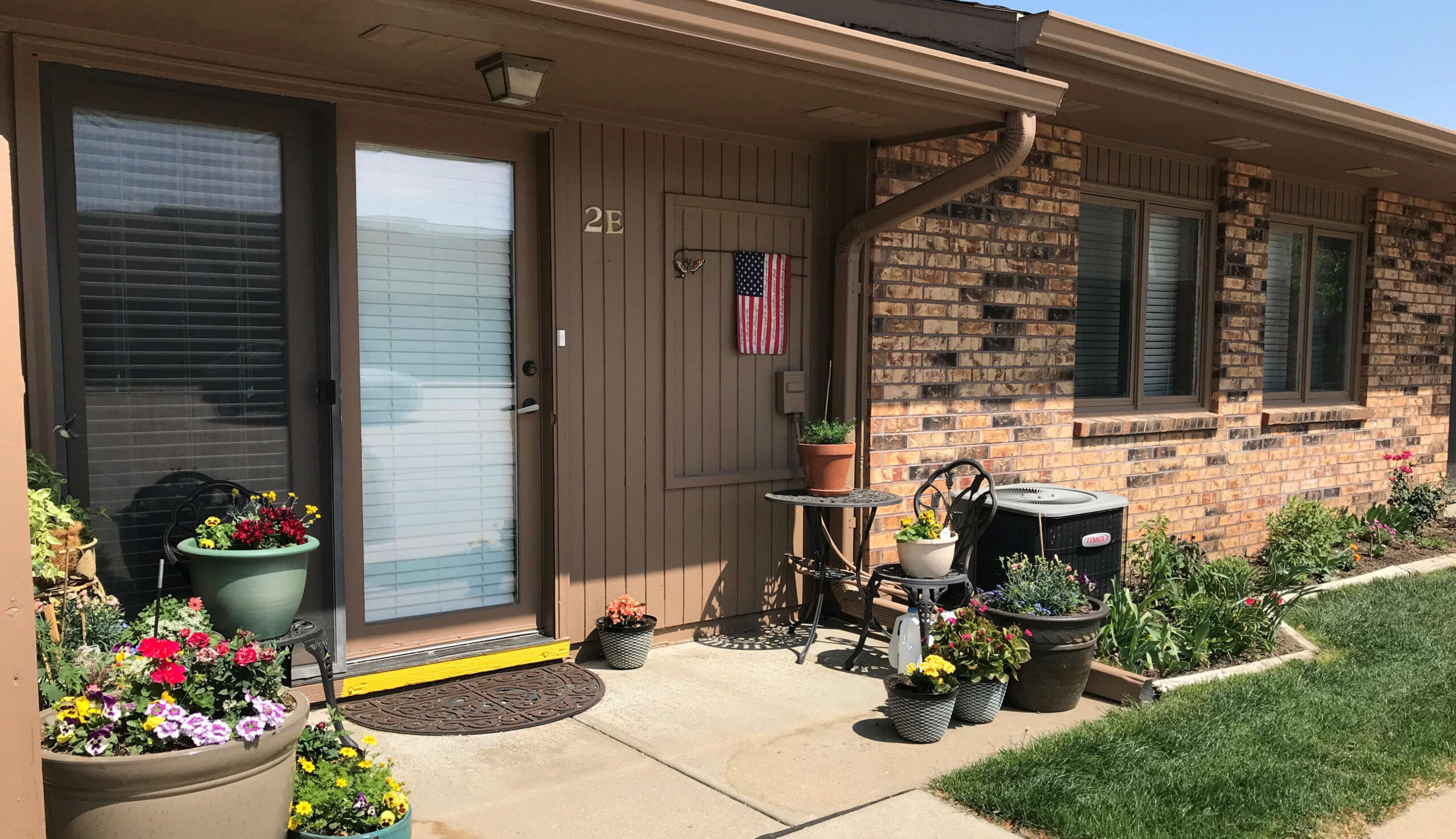 Front door with flower pots and an American flag