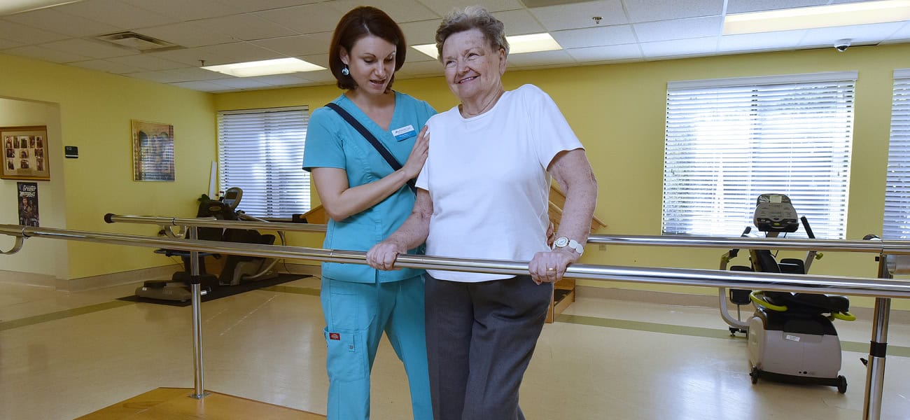 Staff assisting a senior resident in rehabilitation