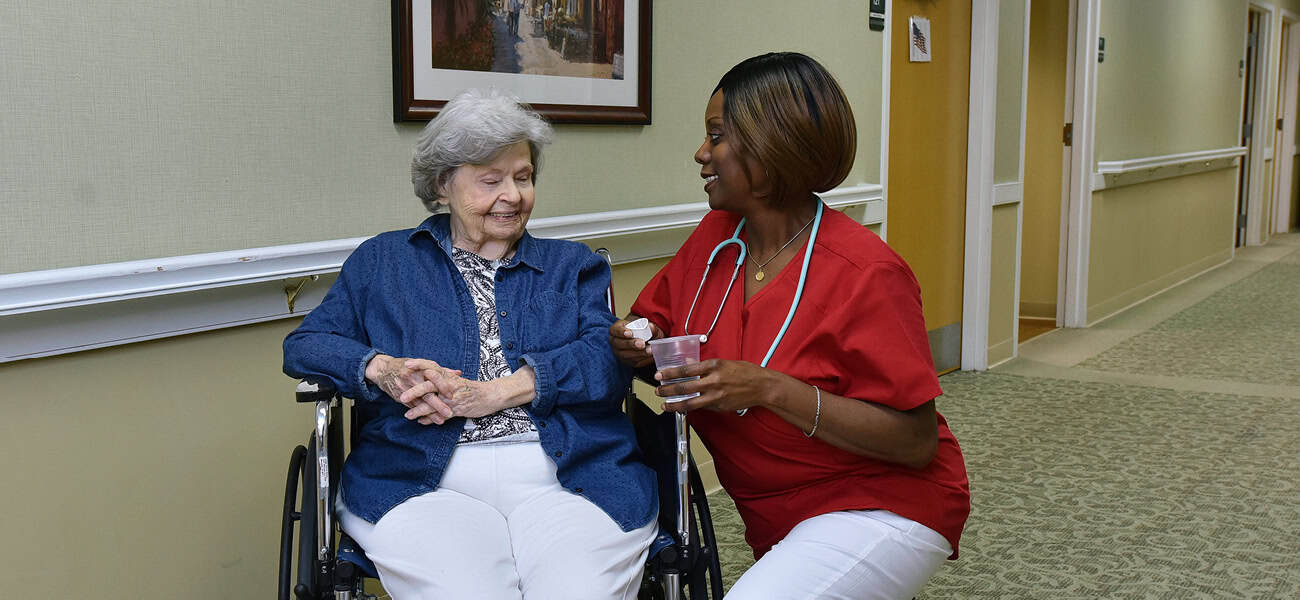 Staff interacting with a resident in a hallway