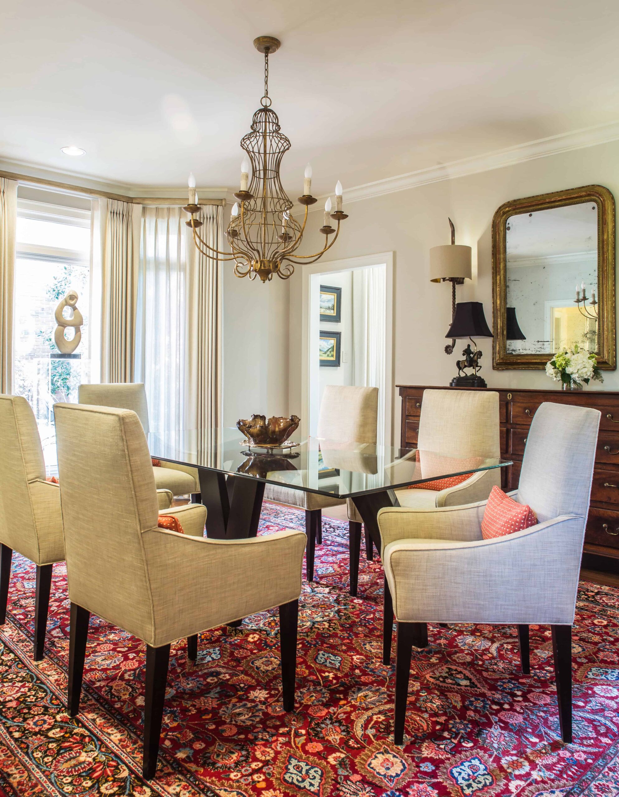 Elegant dining area with chandelier and patterned rug.