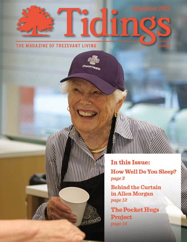 Resident smiling while holding a cup in a common area.