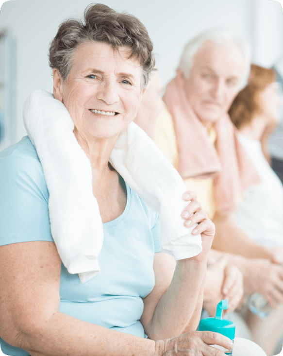 Smiling senior woman with a towel seated in common area