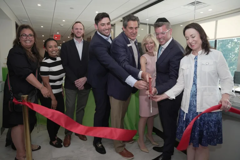 Group ribbon-cutting ceremony with staff and visitors.