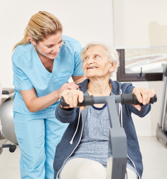 A caregiver assisting a smiling senior with exercise equipment.