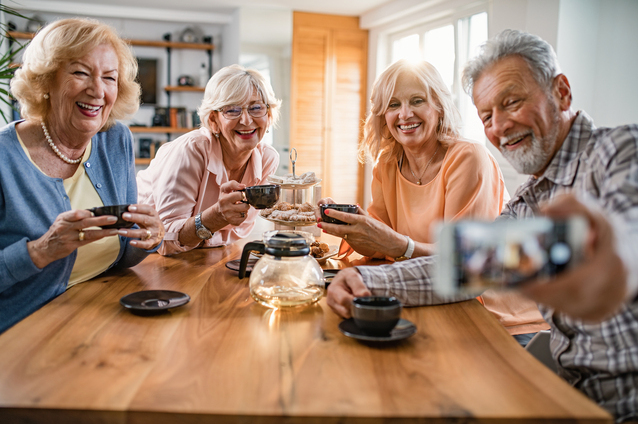 Seniors enjoying tea and conversation around a table.