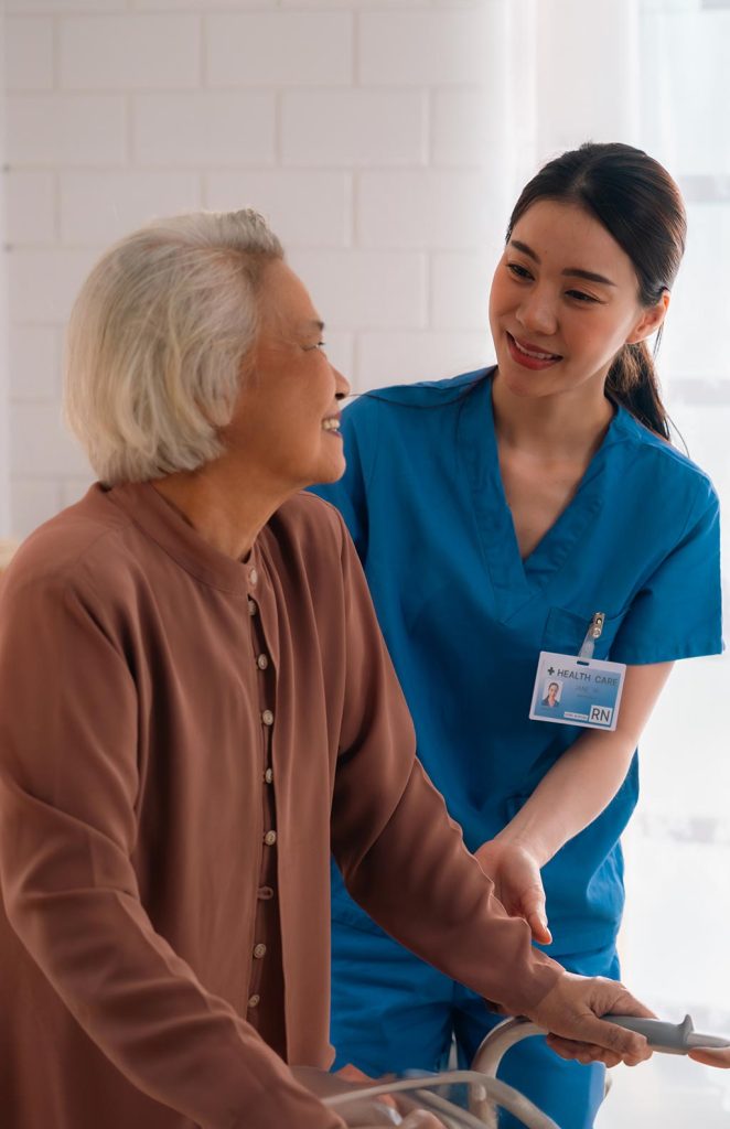 Caregiver assisting an elderly woman indoors.