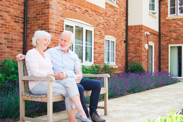 Senior couple enjoying time outdoors on a bench.