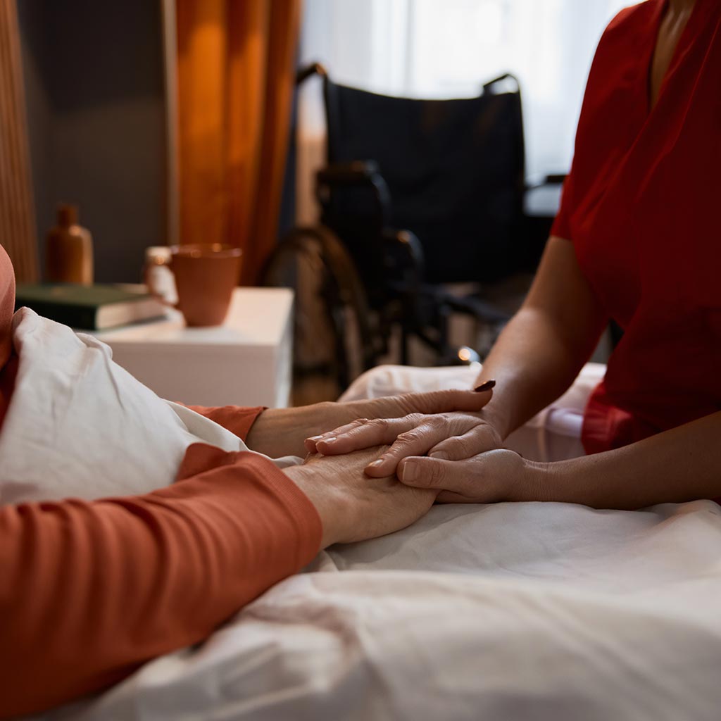 Caregiver holding a resident's hand