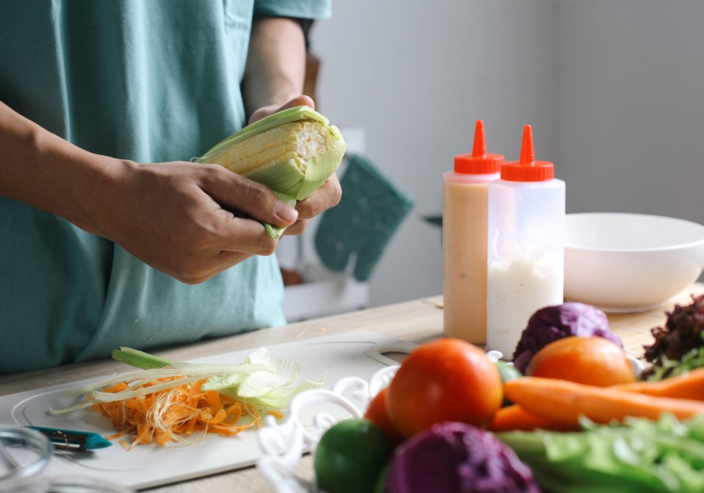 Person preparing fresh vegetables in a kitchen.