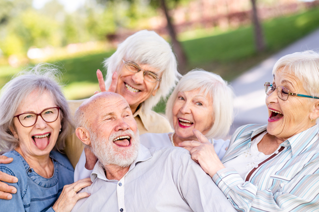 Seniors enjoying time together outdoors with smiles.