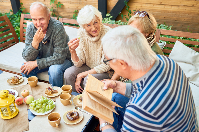 Seniors enjoying snacks and conversation outdoors
