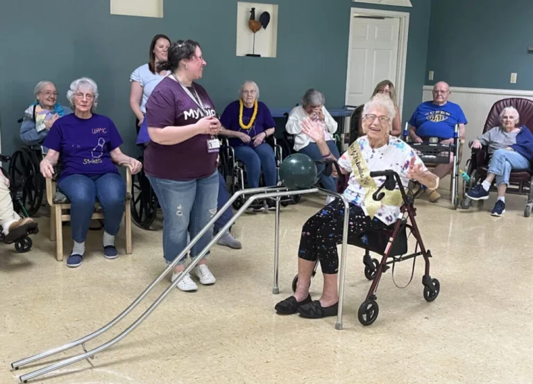 Residents engaging in an activity with staff assistance.