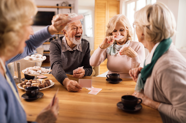 Seniors enjoying a card game at a table.