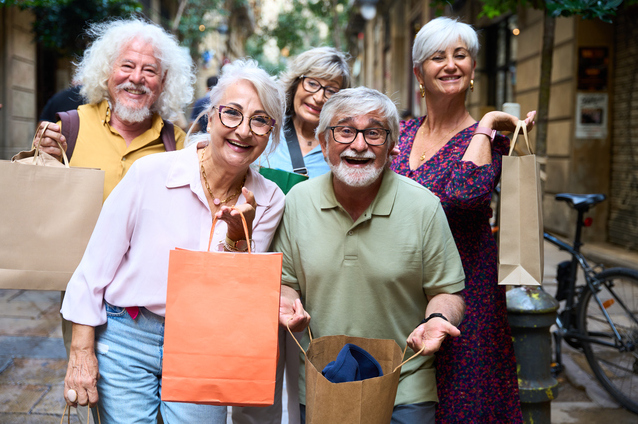 Group of smiling seniors holding shopping bags