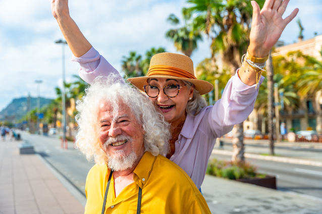 Two smiling seniors enjoying an outdoor setting
