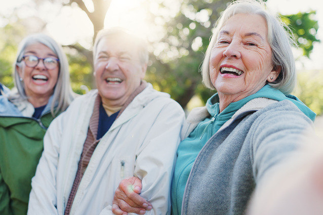 Three residents joyfully smiling outdoors