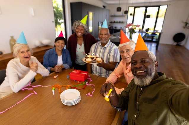 Group celebration with residents enjoying cupcakes.