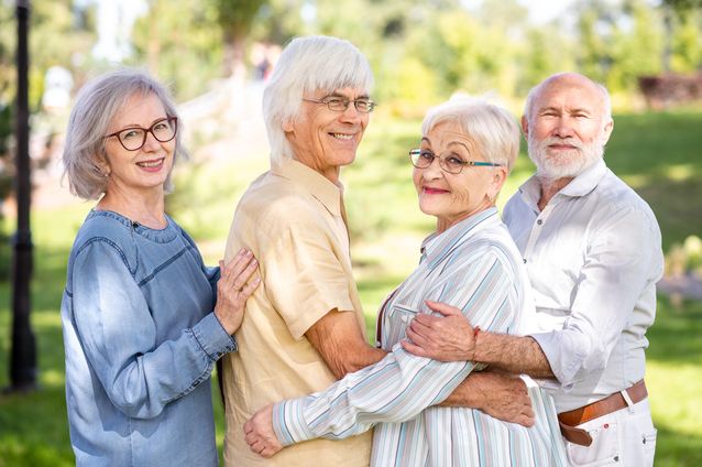 Four seniors enjoying a sunny outdoor moment together.
