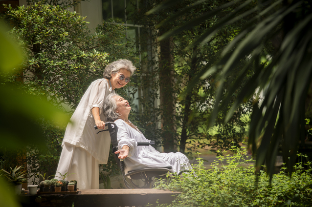 Two women enjoying the garden in a caring moment.