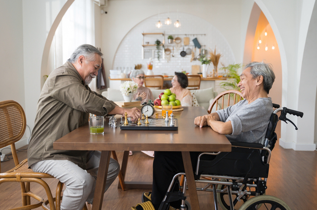 Residents engaging in a chess game indoors.