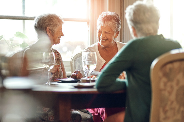 Three seniors enjoying conversation at a table