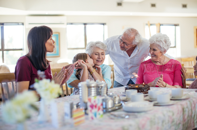 Residents celebrating with staff and family at a table