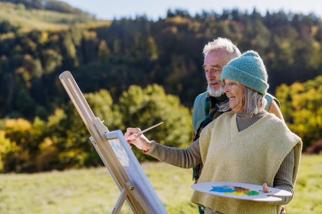 Elderly couple enjoying painting outdoors