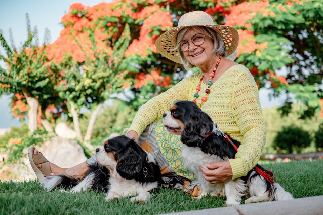 Senior woman enjoying time with dogs outdoors