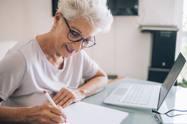 Senior woman writing at a table