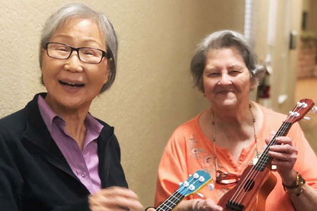Two residents enjoying music with ukuleles