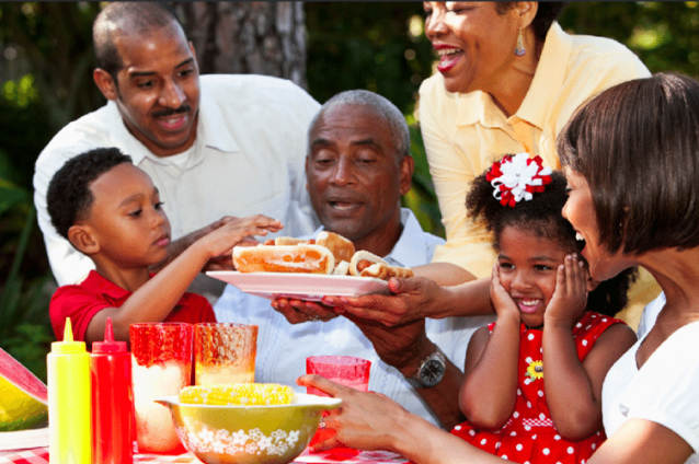 Family gathering outdoors with food and children.