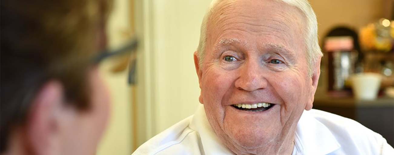 Close-up of a smiling resident in conversation.