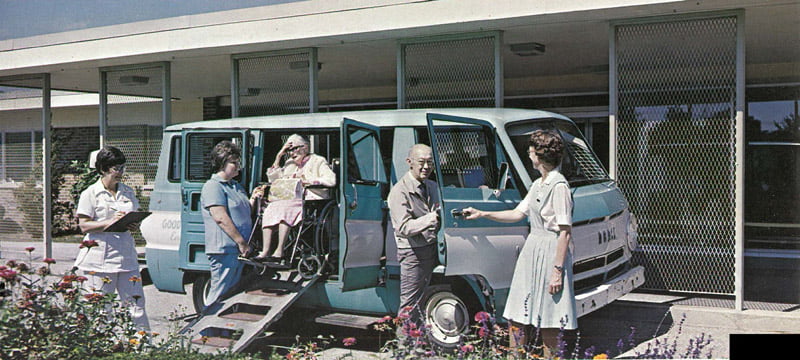 Transport van assisting elderly resident outdoors