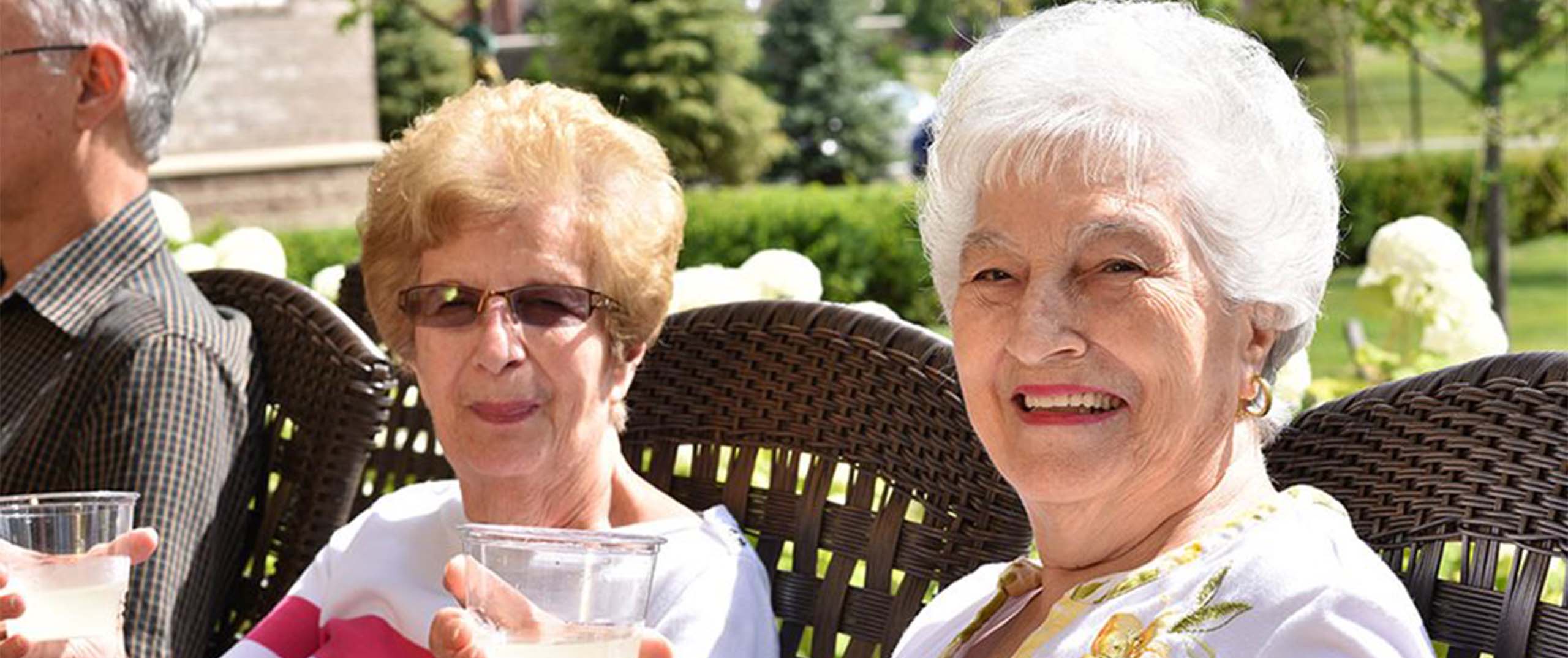 Two seniors enjoying drinks outdoors