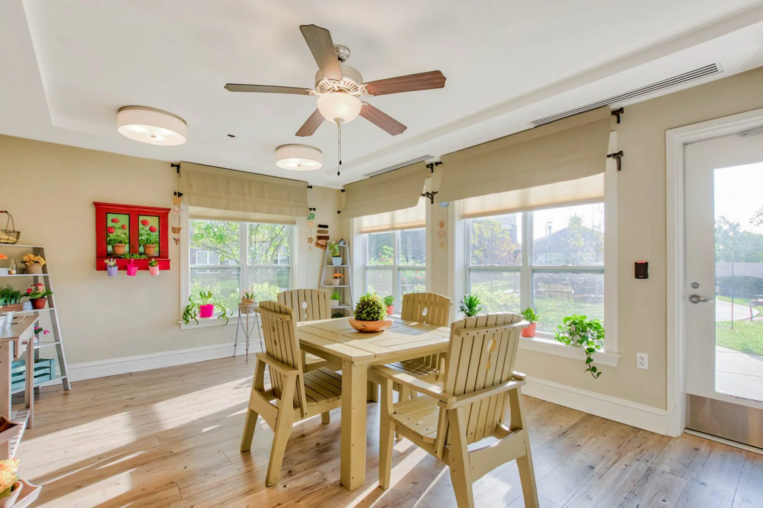 Bright common area with wooden furniture and plants.