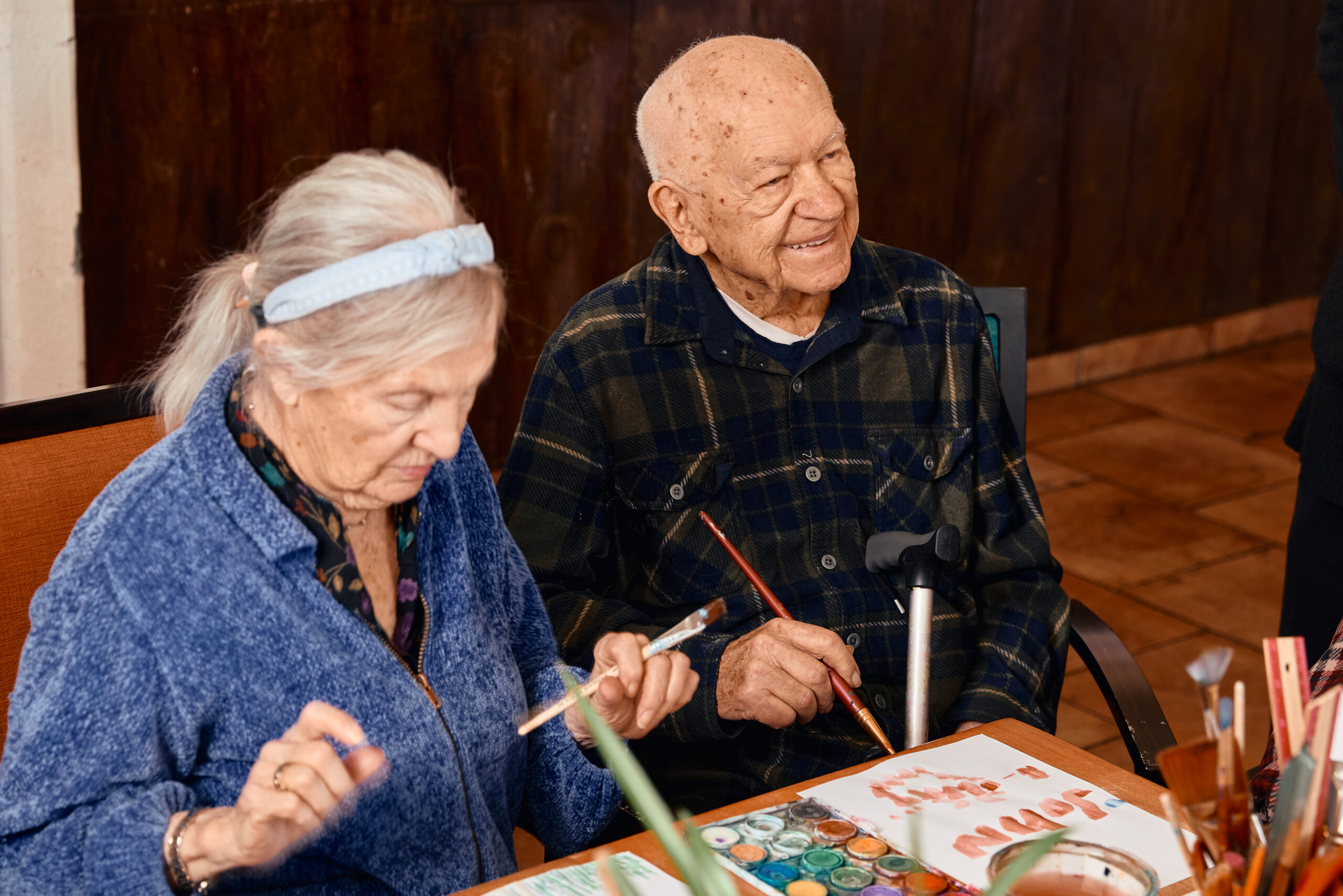 Two seniors engaged in an art activity.