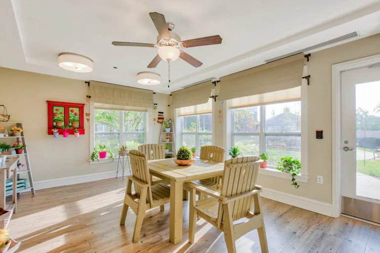Bright common area with a dining table and plants.