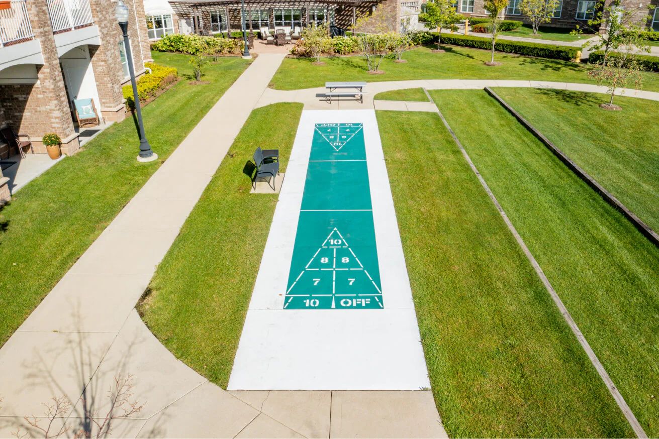 Outdoor shuffleboard court with green grass and pathways