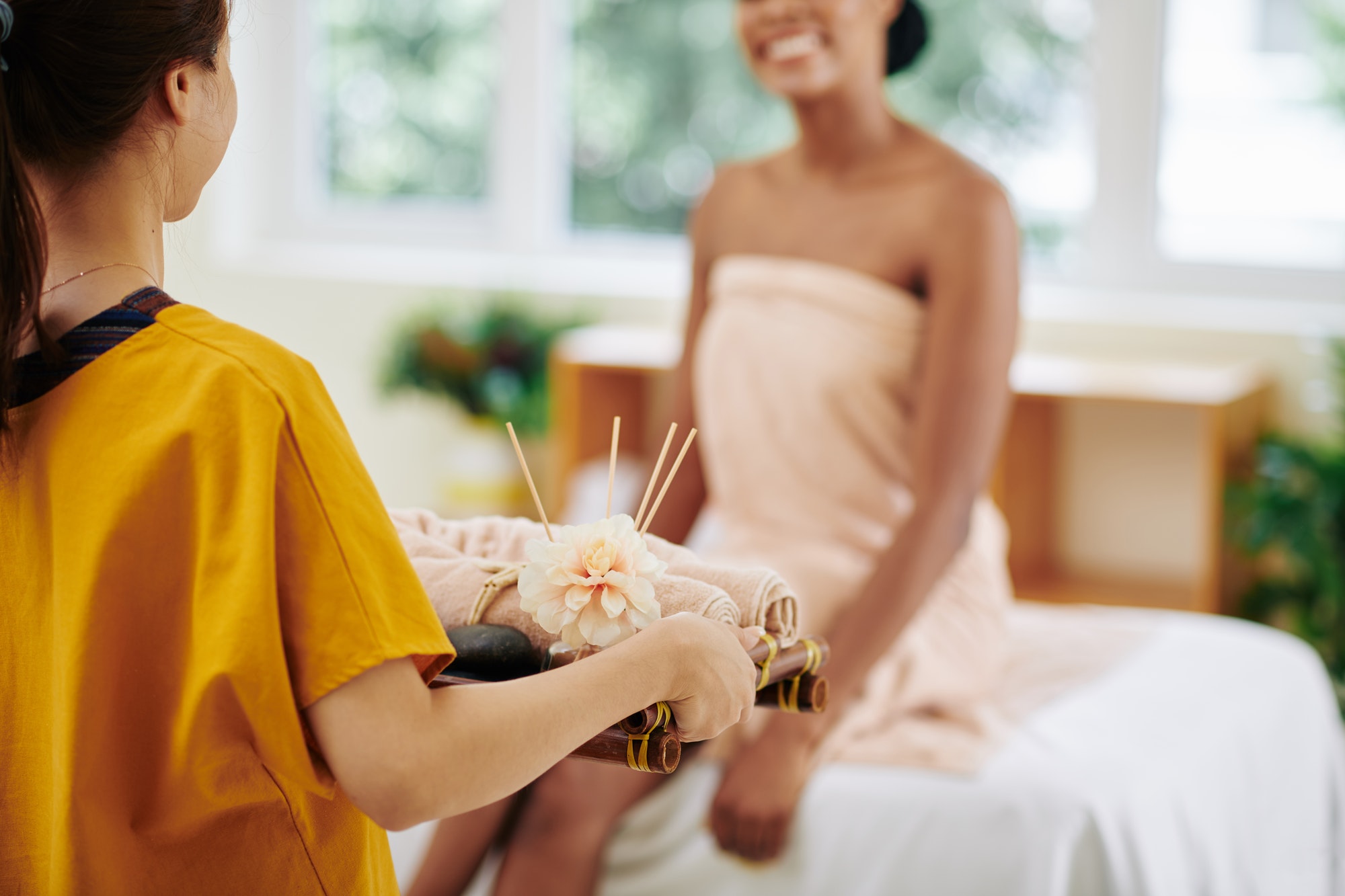 Spa treatment with towels and flowers in a therapy room.