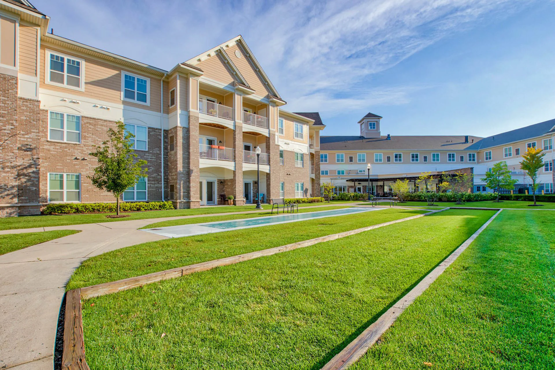 Exterior view of Rose Senior Living with lawn and landscaping.