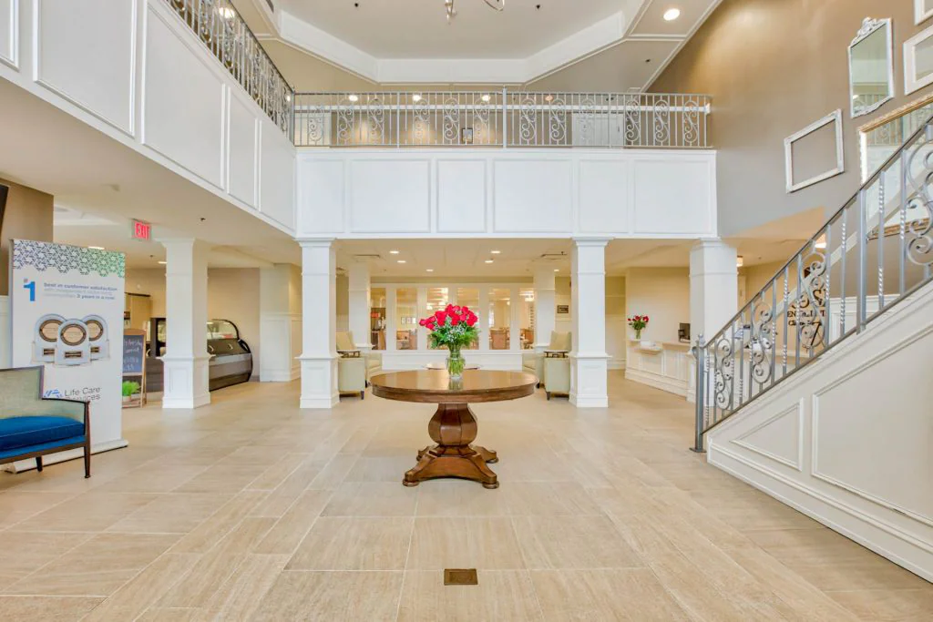 Spacious lobby area with a round table and floral arrangement.