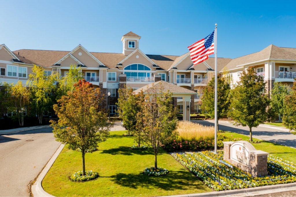 Exterior view of Rose Senior Living with American flag